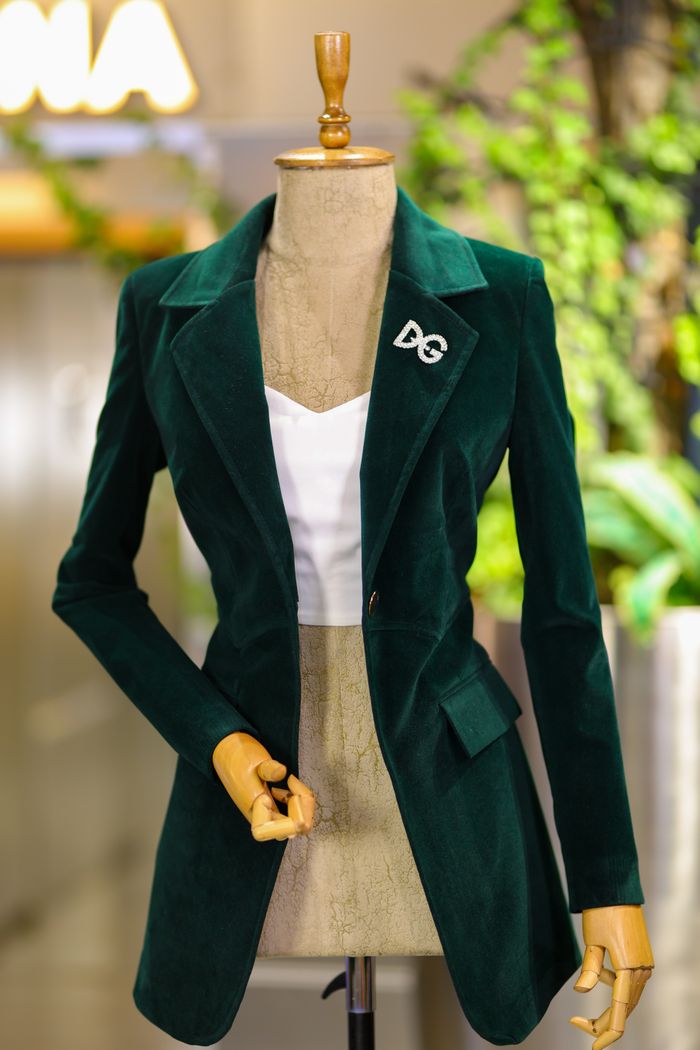 services-03 Fashionable green jacket displayed on a mannequin in a stylish clothing store