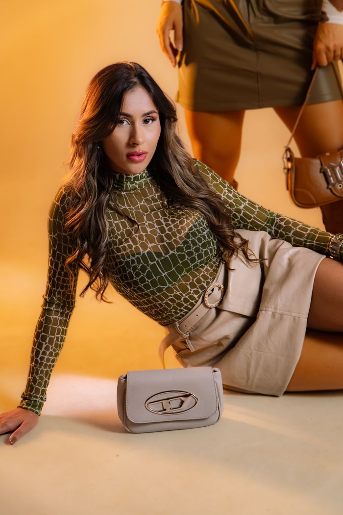 services-04 Model poses with elegance in trendy clothing and handbag against a soft background.